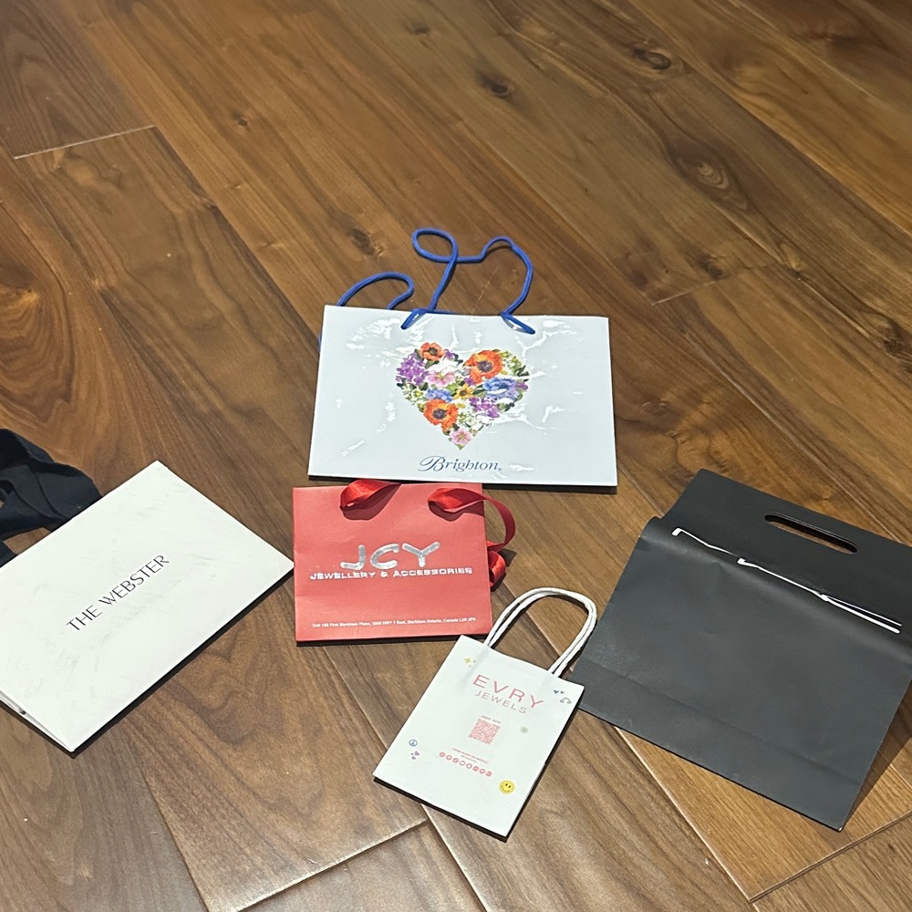 Brighton White Bag with Floral Heart Design and various other paper bags.